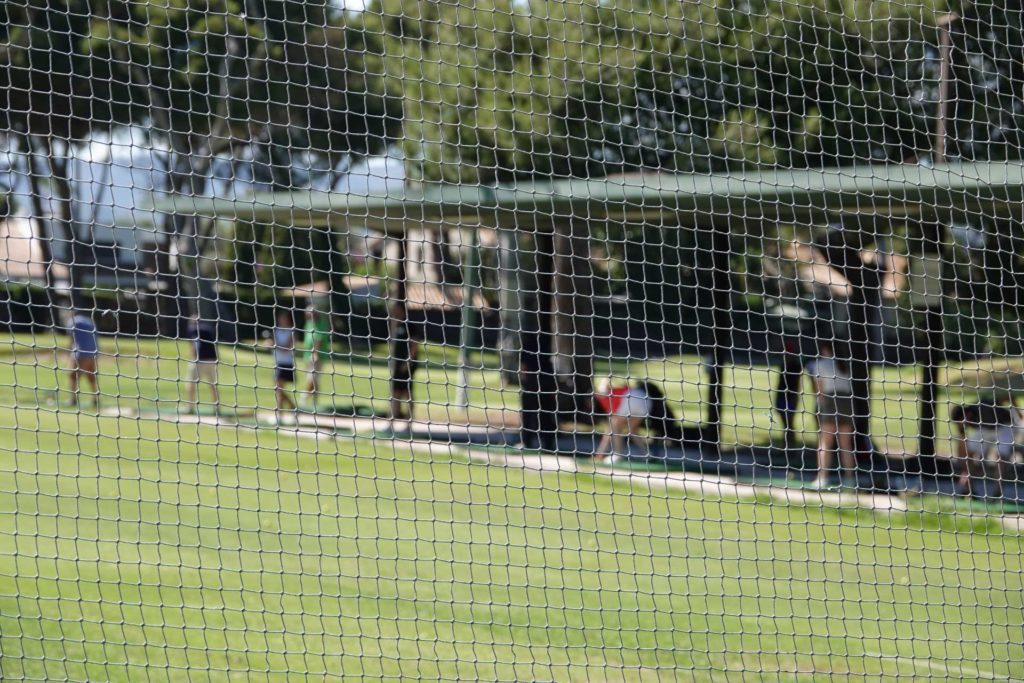 A view of a cricket net setup in a field.